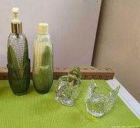 Full set showing two corn bottles and two glass birds with ruler for scale