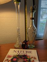 Both glass vases on desk with craft book visible