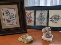 Group view of both framed prints, soapstone carving and stone candle holder