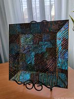 Front of square iridescent fused glass platter on stand