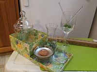 Full lot displayed on floral box: jar with lid, wine glass, carafe, candle holder, marbles, olive picks