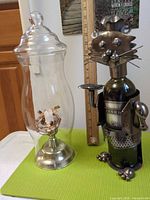 Hurricane candle holder beside cat metal wine holder showing overall items