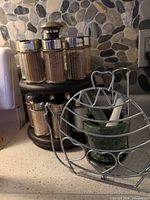 Spice rack with shakers, wire trivet holding mortar and pestle