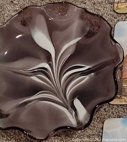 Top view showing white feather swirl pattern and ruffled rim