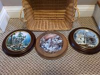 All three framed porcelain plates displayed on floor
