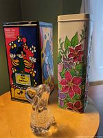 group shot showing glass figurine and two decorative tins
