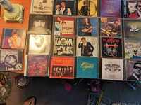 Overview of all 22 jewel-case CDs spread on floor