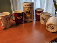 Front view showing five mugs and commemorative canister