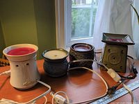All four ceramic wax warmers lined up showing colours, shapes and cords