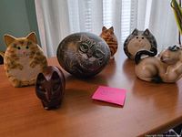 Group shot of six cat figurines on table