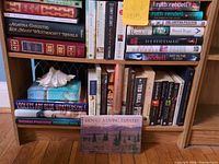 Full shelf view showing mix of books and seashell