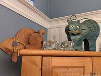 Wooden cat, metal cat, two glass tealight cats on cabinet