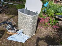 Hamper open with hangers and planter on ground