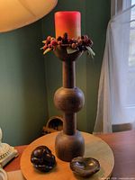 Overall view showing wood candlestick with candle and decorative ring, carved wood figure, polished agate bowl