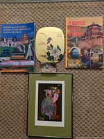 All five items laid out: framed print, two guidebooks, decorative tin, crystal block