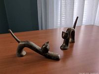 Both brass cat sculptures on tabletop showing overall forms