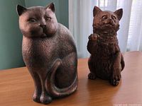 Front view of both resin cat figurines on tabletop