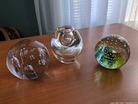 All three glass paperweights on table