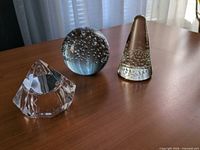 All three glass paperweights on tabletop