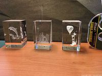 Three optical crystal paperweights lined up on table