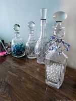 All four decanters on wood surface