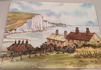 Placemat with coastal cliffs and cottages illustration, Valerie Sadler signature visible