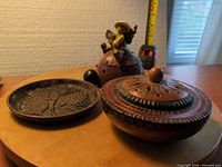 Wooden trinket box, metal dish, ceramic ladybug box shown together for scale and overview