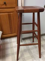 Full view of stool showing legs, stretchers, finish