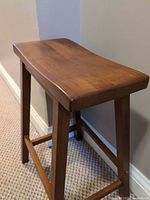 Three-quarter view of stool showing seat, legs and finish