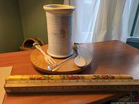 Crock standing on table with utensils and storage tube in foreground