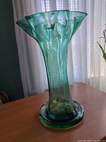 Full view of vase on base showing color gradient and overall form