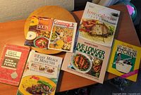 All seven cookbooks laid out showing covers