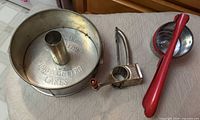 Swans Down cake pan, rotary grater and potato press grouped together