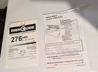 EnerGuide label 276 kWh/year and owner's manual on freezer lid