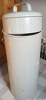 Full view of cream metal milk can with lid and side handles