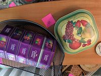 Basket holding stacked Quality Street tins beside lidded fruit tin