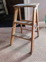 Full view of wooden 2-step folding stool standing open