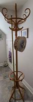Full view of light brown wood coat rack with hooks and hanging decorative box
