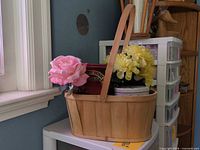 Basket with flowers and tins on shelf