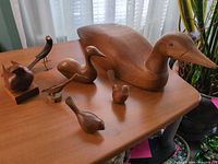 Group shot showing all five wooden bird figures with largest duck decoy