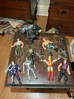 Overview of eight action figures and accessories on tabletop