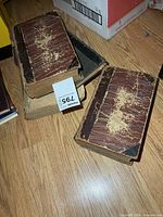 Stack of three antique books showing marbled boards and wear