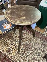 Top view of round side table showing surface wear and painted trim