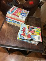 Stack of approximately 30 Archie digest comic books on small table