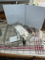 Overall lot with glass bakeware, wedger in bag, grater visible