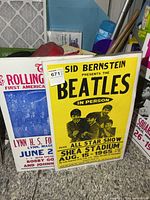 Both posters in plastic sleeves leaning against wall