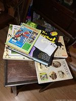 Stack of seven books on small table showing variety of sizes and titles