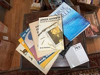 Stack of assorted books and resin totem pole