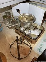 Jars, food mill on top, metal stand in front