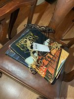 Three stacked hardcover books with two metal stands